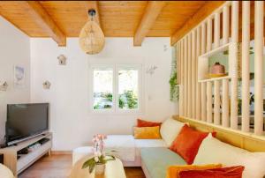 a living room with a couch and a tv at Villa L'Epicléa, Chorges, entre lac et montagnes in Chorges