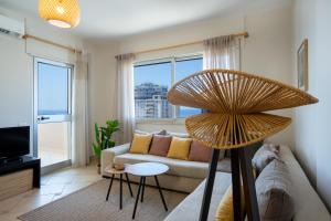a living room with a couch and a large fan at Fole Maison in Durrës