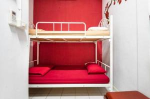 a red bunk bed in a small room at 1137 Hostel in Bangkok