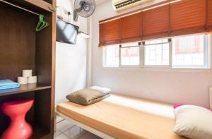a room with a bench in a room with a window at 1137 Hostel in Bangkok