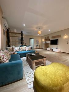a living room with two blue couches and a table at Villa La Gospa in Libreville