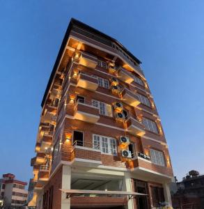 a tall building with lights on the side of it at Hotel happy stay inn in Pashupatināth