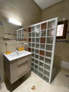 a bathroom with a sink and a glass wall at Villa La Gospa in Libreville