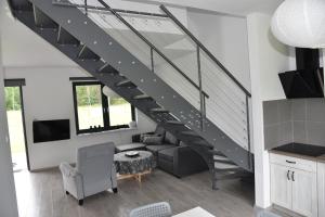 a staircase in a living room with a couch and a table at Lubiatówki in Lubiatowo