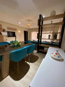 a living room with blue chairs and a table at Villa La Gospa in Libreville