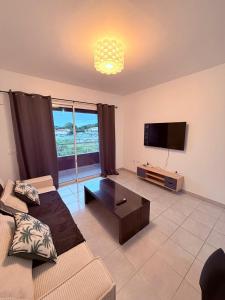 a living room with a couch and a flat screen tv at Le Petit Refuge in Cayenne