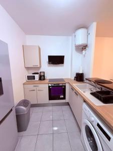 a small kitchen with a sink and a washer at Le Petit Refuge in Cayenne