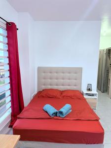 a bedroom with a red bed with a bow tie on it at Le Petit Refuge in Cayenne