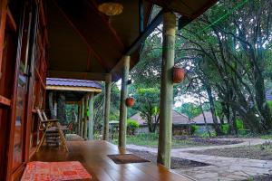 a porch of a house with a table and chairs at Mara Chui Eco-Resort in Sekenani