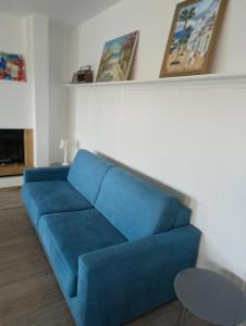 a blue couch in a living room with paintings at Apfelblüte in Stockach
