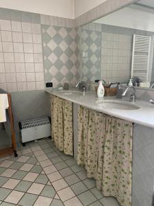 a bathroom with two sinks and a mirror at La Cà di Carol Apartment in Andorno Micca