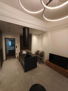 a living room with a television and a couch and chairs at Orestiada Centro apartment in Orestiada
