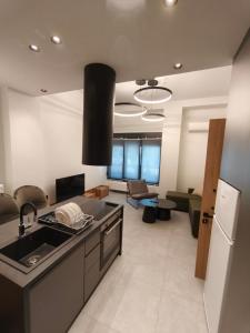 a kitchen with a sink and a living room at Orestiada Centro apartment in Orestiada