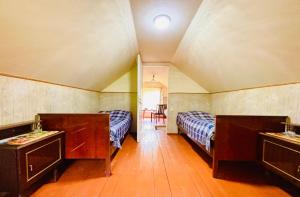 a bedroom with two beds and a table and chairs at Villa Bubi in Tbisi