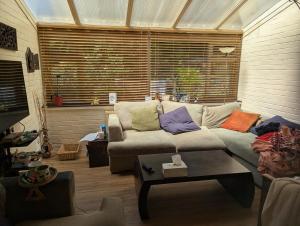 a living room with a couch with colorful pillows on it at Rashas double room in London