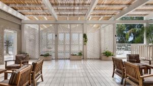 a patio with chairs and tables and a wooden ceiling at Jacob Nea in Shave Ẕiyyon