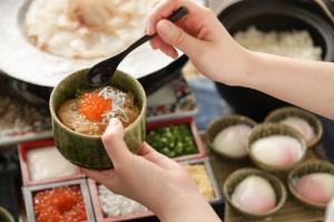 a person holding a bowl of food with a spoon at Hotel Monterey Sendai in Sendai +72 photos