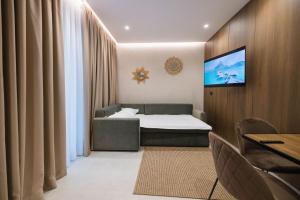 a bedroom with a bed and a tv on a wall at Hotel Digreis in Vlorë