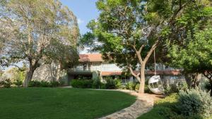a house with a green lawn and a tree at Jacob Nea in Shave Ẕiyyon