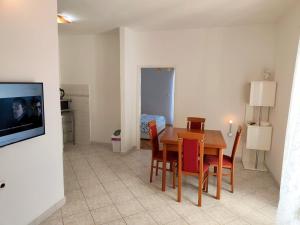 a dining room with a table and chairs and a television at Apartment Mila in Primošten