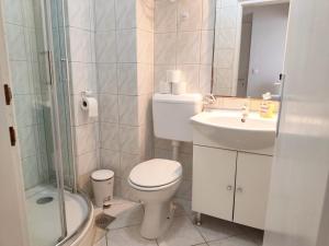 a bathroom with a toilet and a sink and a shower at Apartment Mila in Primošten +11 photos
