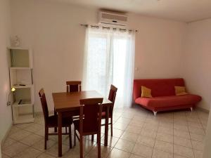 a living room with a table and a red couch at Apartment Mila in Primošten