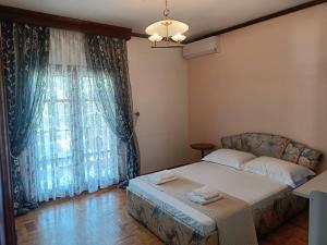 a bedroom with a bed and a large window at Villa Orfani in Orfánion