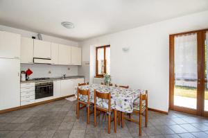 a kitchen with a table and chairs and a kitchen with white cabinets at Fausta Lago in Colico
