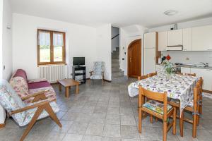 a living room with a table and chairs and a kitchen at Fausta Lago in Colico +6 photos