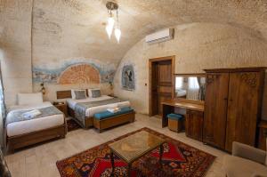 a bedroom with two beds and a desk in a room at Grand Cappadocia Hotel in Göreme +79 photos