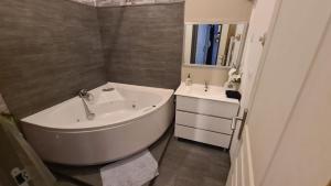 a bathroom with a bath tub and a sink at Appart cosy avec balnéo, balcon, clim à 15 min de la Cité in Carcassonne +6 photos