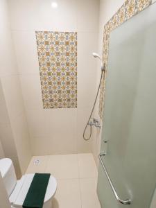 a bathroom with a shower and a toilet at Grand Kalimas Hotel in Surabaya