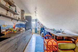 a kitchen with a long counter and some chairs at Appartement auf dem Land in Neuenkirchen