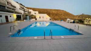 a large swimming pool with blue water in a building at Inagua Sol apartment in Puerto Rico de Gran Canaria