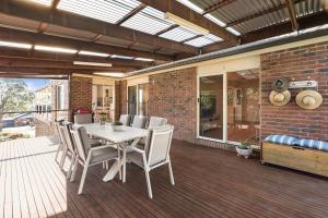a patio with a table and chairs on a deck at The Lakeview in Lilydale