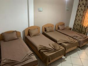 a room with three beds in a room at Montazah Residence in Dar el Koudia
