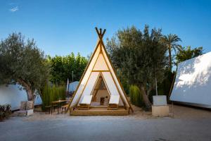 a triangular triangular tent with a table and chairs at Kampaoh Playa de Levante in Benidorm
