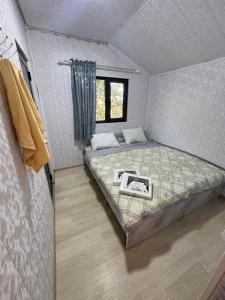 a small bedroom with a bed and a window at SELKINCHEK resort in Kugart
