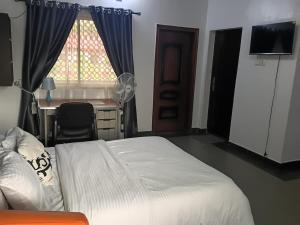 a bedroom with a bed and a desk and a window at Engelbert Beyer Centre in Ibadan