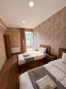 a hotel room with two beds and a window at Sky Star in Kazbegi