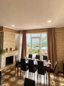 a dining room with a table and chairs and a large window at Sky Star in Kazbegi
