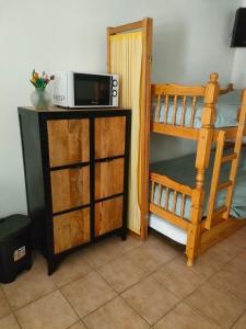 a room with a bunk bed and a microwave on a counter at Le Tinou in Cazilhac