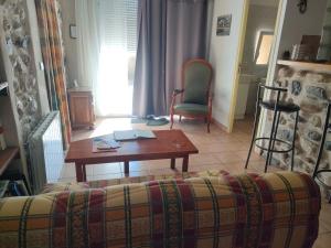 a living room with a couch and a table and chairs at Le Tinou in Cazilhac