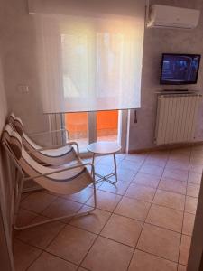 a chair and a table in a room with a television at La Terrazza in Civitavecchia