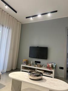 a living room with a table and a flat screen tv at Appartement Cassia Vue Piscine rénovée cette année in Cabo Negro