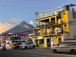a street with cars parked in front of a building at Mayon Lodging House in Legazpi