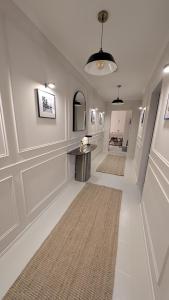 a hallway with white walls and a table and a rug at FREISTIEL 4 in Hattenheim
