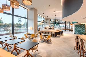 a restaurant with tables and chairs and a bar at Sercotel Rosaleda Málaga in Málaga