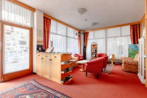 a living room with a table and chairs and windows at Garni Lago Nembia in San Lorenzo in Banale