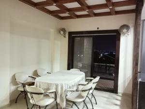 a white table and chairs in a room with a window at 3BHk flat family friendly in Raipur